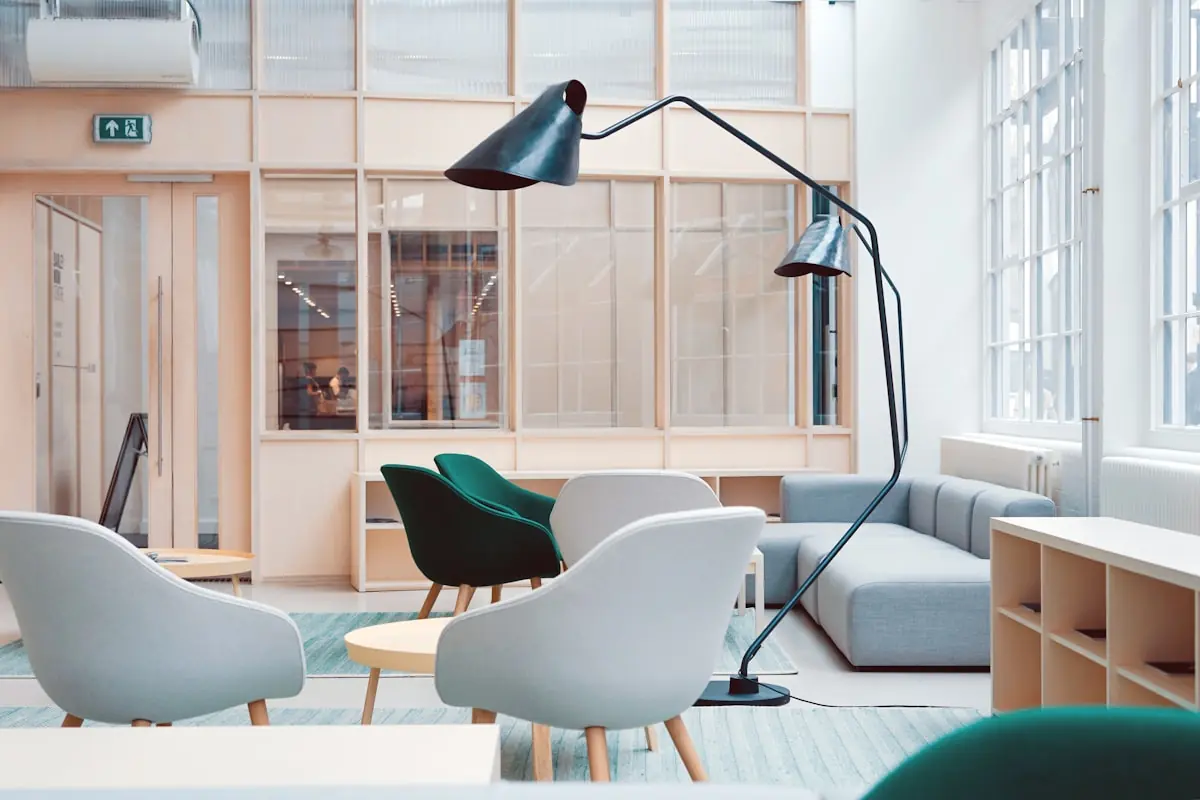 A bright, light-filled communal lounge with soft armchairs and tall windows — representative of the calm spaces at St. Maximilian.